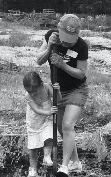 Mother and daughter using a shovel in a garden
